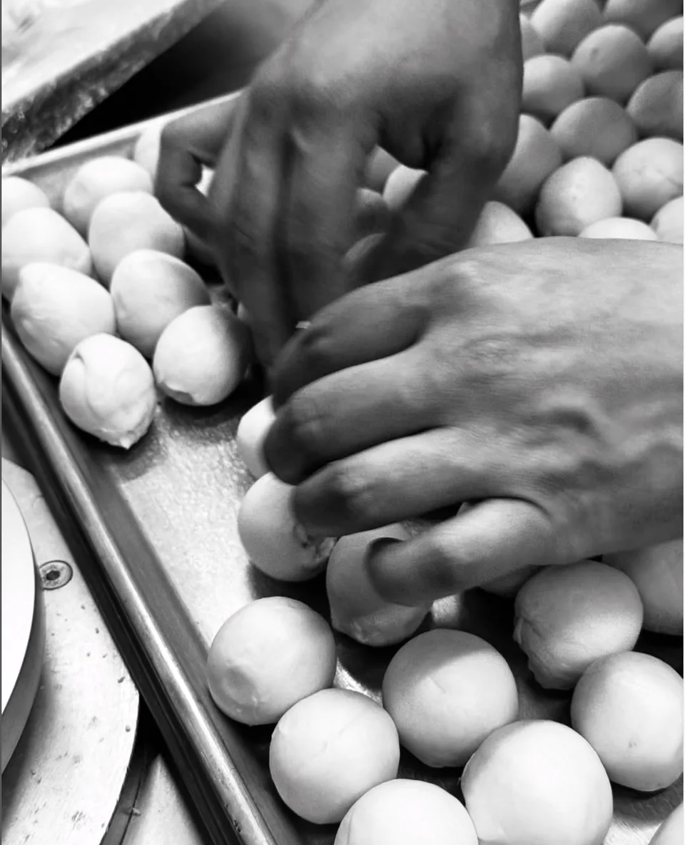 Manos formando porciones de masa para las tortillas de harina La Herencia