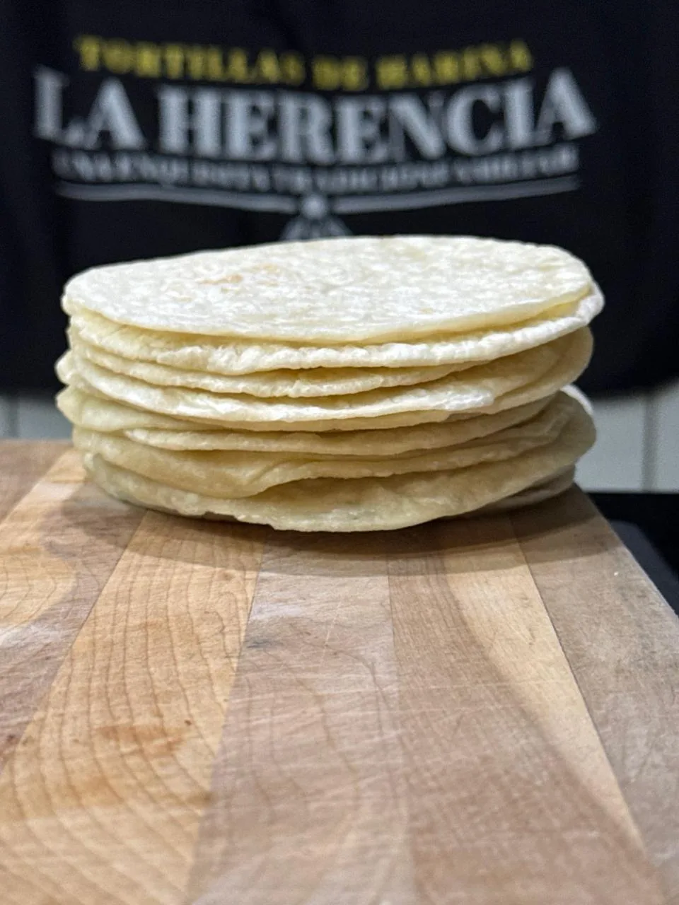 Pila de tortillas de harina La Herencia sobre una tabla de madera